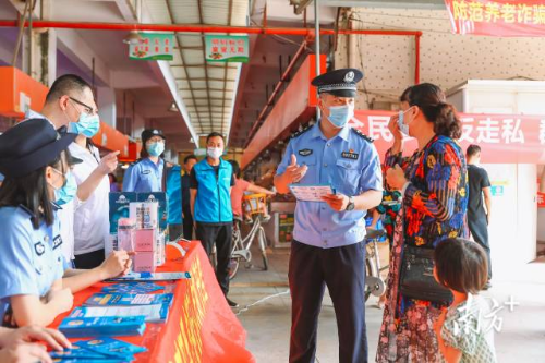社区民警在市场门口开展防范养老诈骗违法犯罪宣传活动。受访者供图